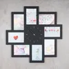 A black photo frame clock with multiple picture slots arranged around a central clock face. Produktbild-Vorschau