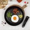 A breakfast meal of fried egg, bacon, arugula, and avocado is served in a black frying pan on a wooden board. Voir les images du produit