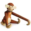 A wooden monkey toy is shown sitting against a white background. Náhled obrázku produktu