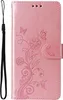 A pink flip phone case with a floral and butterfly embossed design and a black wrist strap. Produktbild-Vorschau
