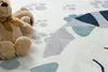 A close-up of a children's rug with paw prints and a cartoon cat design, featuring a teddy bear. Podgląd zdjęcia produktu