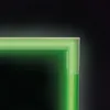 A close-up view of the corner of a rug with a neon green pattern against a dark background. Podgląd zdjęcia produktu