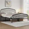 A black metal bed frame with a headboard and footboard, set up in a bedroom with bedding and a rug. Produktbild-Vorschau