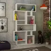 A modern white bookshelf filled with books and decorative items, set against a textured gray wall with artwork. A bronze dog statue sits beside the bookshelf. Produktbild-Vorschau