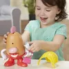 A young girl is playing with a Mr. Potato Head toy. Anteprima dell’immagine prodotto