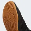 A close-up view of the sole and side of a black Adidas sneaker. Voir les images du produit