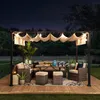 An outdoor patio set under a pergola at night, illuminated by string lights. Produktbild-Vorschau