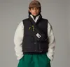 A person wearing a vest, fleece jacket, and hat, with a bag across their chest. Produktbild-Vorschau