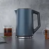 A blue electric kettle and two glasses of tea on a dark countertop with a textured gray wall in the background. Náhľad obrázku produktu