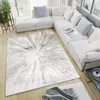 A modern living room with a sectional sofa and a large rug. Voir les images du produit