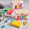 A collection of colorful fondant blocks and pre-made fondant decorations, arranged on a gray surface. Produktbild-Vorschau