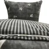 A close-up view of a grey and white striped duvet cover with a star pattern on a pillow. Produktbild-Vorschau