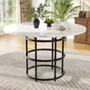 A round dining table with a marble-effect top and a black metal base, set in a dining room with plants and a chest of drawers visible in the background. Produktbild-Vorschau