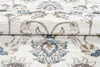A close-up view of a cream-colored rug with a classic floral design in light gray and blue. Produktbild-Vorschau
