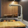 A close-up view of a modern kitchen sink area with a beige faucet, wooden cutting board, and fruit. Podgląd zdjęcia produktu