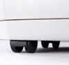 A close-up view of the bottom of a white appliance, showing its black wheels and housing. Voir les images du produit