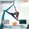 A woman is performing aerial yoga on a teal hammock against a sky background. The image compares the product's fabric to 'other' fabrics, highlighting its features. Voir les images du produit