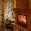 A decorative wooden Christmas tree with LED lights is placed next to a fireplace. Náhled obrázku produktu