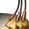 A close-up shot of a UGREEN audio cable with a 3.5mm jack and two RCA connectors, resting on a vinyl record. Náhled obrázku produktu