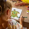 A young girl is coloring a picture of a turtle with markers. Produktbild-Vorschau