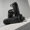 Three black thermos bottles are arranged on a light gray surface with a light gray background. Produktbild-Vorschau