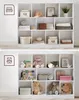 A white cube shelf unit filled with various decorative items and storage boxes. Produktbild-Vorschau