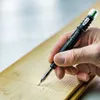 A hand is using a Pica Fine-Dry marker to draw a line on a wooden plank. Anteprima dell’immagine prodotto
