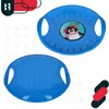 A collage of two images showing a blue plastic sled from different angles, with a graphic of a penguin on one of them. There are also graphic elements in the top left and bottom right corners. Náhled obrázku produktu