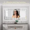 A woman is touching her face in front of a large, illuminated bathroom mirror. Produktbild-Vorschau