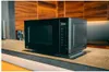 A black Panasonic microwave oven is placed on a wooden countertop in a modern kitchen. Anteprima dell’immagine prodotto