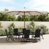 A patio set with a large umbrella, table, and chairs on a paved patio, surrounded by greenery and a wooden fence. Náhľad obrázku produktu