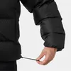 A close-up of a person's hand adjusting a drawstring on a black puffer jacket. Voir les images du produit