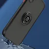 A black iPhone XR case with a red accent is shown at an angle, with a ring holder attached. The case appears to be falling onto a surface that is breaking apart. Voir les images du produit