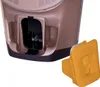 A close-up view of a small compartment on a brown appliance with a yellow cap next to it. Produktbild-Vorschau