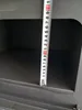 A close-up shot of a measuring tape inside a dark compartment of a stove. Produktbild-Vorschau