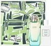 A gift set featuring a perfume bottle and a decorative box with a tropical print. Voir les images du produit