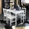 A white dining set with four chairs and a table is shown in a room with a bookshelf. Anteprima dell’immagine prodotto