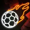 A neon LED light shaped like a soccer ball with flames, displayed on a dark, textured surface. Podgląd zdjęcia produktu