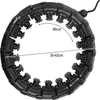 A black hula hoop with adjustable segments and massage nubs is shown against a white background. Dimensions are indicated with text and arrows. Produktbild-Vorschau