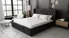 A bedroom scene featuring a large, upholstered bed.