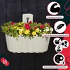 A white planter filled with red, yellow, and white flowers is mounted on a dark wooden wall. Marketing graphics with text and icons are overlaid on the right side of the image. Podgląd zdjęcia produktu
