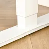 A close-up view of the base of a white adjustable desk leg on a wooden floor. Podgląd zdjęcia produktu