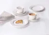 A coffee service set with cups, saucers, and plates arranged on a white surface, with a napkin and a biscotti cookie. Produktbild-Vorschau