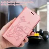 A hand holding a pink phone case with a lotus flower design. Produktbild-Vorschau