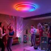 People dancing in a room with colorful lights and a speaker. Produktbild-Vorschau