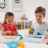Two children are playing with kinetic sand in a room. Voir les images du produit