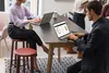 People working on laptops at a table in an office setting. Voir les images du produit