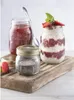 Three jars of preserves and chia seeds are arranged on a wooden board, with a spoon in one of the jars. Produktbild-Vorschau