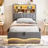 A bedroom scene featuring a single bed with a headboard that has integrated shelving and lighting. Náhľad obrázku produktu
