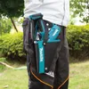 A person wearing work pants and a jacket is holding a tool pouch with Makita tools inside. Produktbild-Vorschau